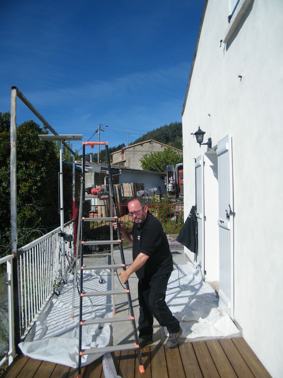 Simão Fernandes, métallier Prometal, installe son échelle sur une terrasse avant la pose d'un ouvrage