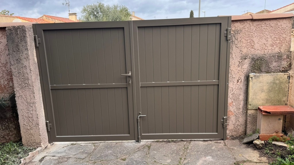 Portail battant en aluminium encastré dans un mur de pierre — Vic-la-Gardiole