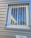 Grille de défense en acier thermolaqué blanc sur fenêtre coulissante aluminium
