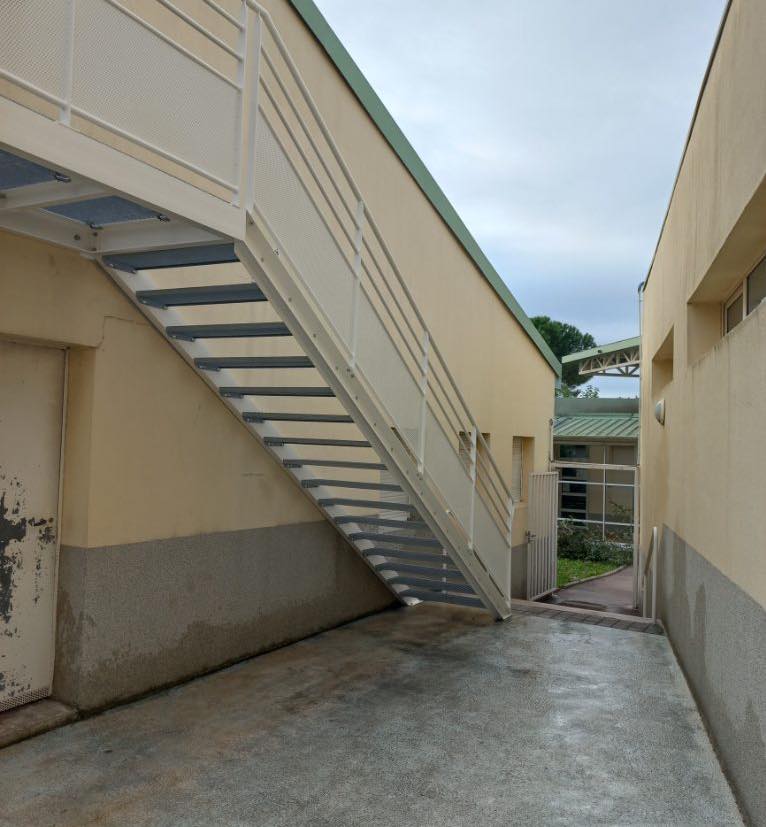 Escalier d'accès en acier thermolaqué sous la passerelle — école élémentaire
