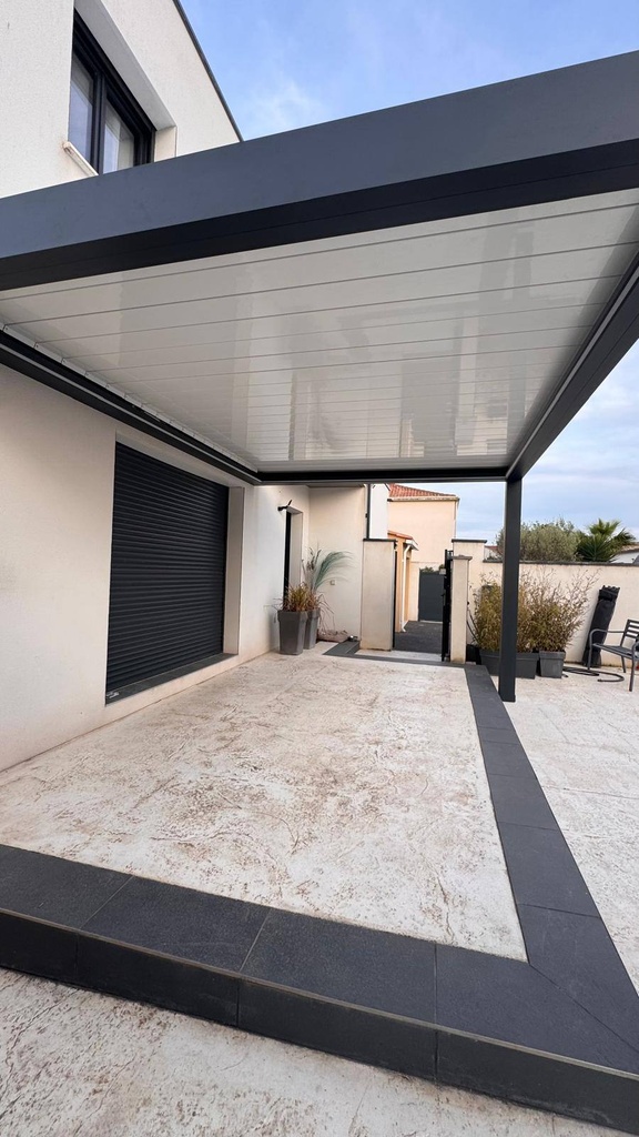 Pergola en aluminium anthracite couvrant une terrasse, avec toiture à lames